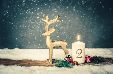 burning candle from 2 nd advent in front of vintage background and decorative christmas background...