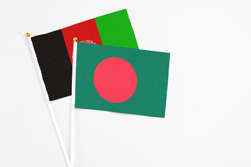 Bangladesh and Afghanistan stick flags on white background. High quality fabric, miniature national flag. Peaceful global concept.White floor for copy space.