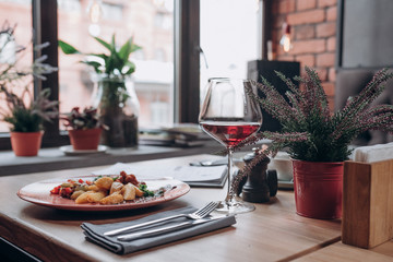 a glass of red wine and dishes on the table in the restaurant