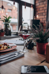 a glass of red wine and dishes on the table in the restaurant