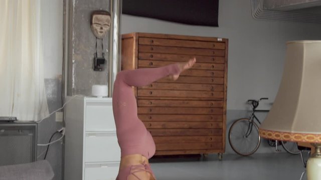Young blonde woman makes yoga workout in her home loft. natural sunlight in rey loft space