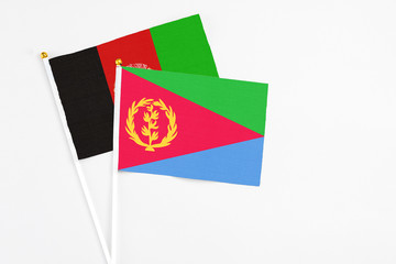 Eritrea and Afghanistan stick flags on white background. High quality fabric, miniature national flag. Peaceful global concept.White floor for copy space.