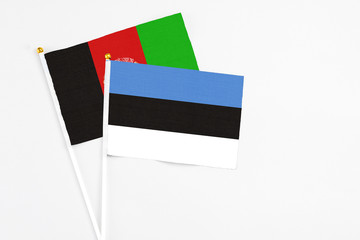 Estonia and Afghanistan stick flags on white background. High quality fabric, miniature national flag. Peaceful global concept.White floor for copy space.