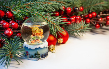  Christmas background with snow globe, spruce branches and reddish decorations