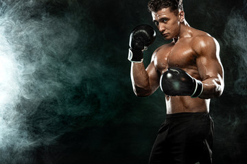 Boxer, man fighting or posing in gloves on black background. Fitness and boxing concept. Individual sports recreation.