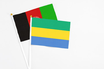 Gabon and Afghanistan stick flags on white background. High quality fabric, miniature national...
