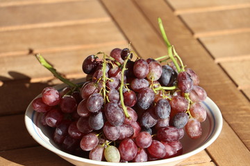 Ripe red grapes from Crete / Greece on wooden table, late autumn harvest