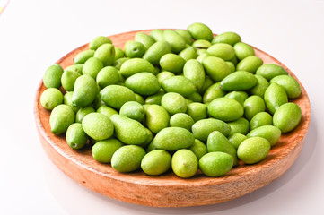 Fresh green olives with branches and leaves. Seasonal harvest in Italy. Top view.