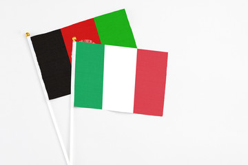 Italy and Afghanistan stick flags on white background. High quality fabric, miniature national flag. Peaceful global concept.White floor for copy space.