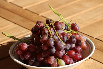 Ripe red grapes from Crete / Greece on wooden table, late autumn harvest