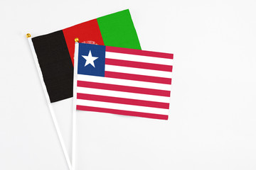 Liberia and Afghanistan stick flags on white background. High quality fabric, miniature national flag. Peaceful global concept.White floor for copy space.