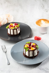 Mini round souffle cake with fruit and chocholate glaze on topc on marble background. Wallpaper for pastry cafe or cafe menu. vertical.