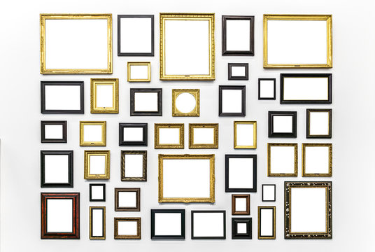 Plenty of white clipped paintings frame hanging on a white wall. Copy or empty space for mockups or templates. Museum Art exhibition.