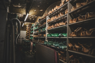 Dark storage with shelves and many forms for creating different shoes and boots.