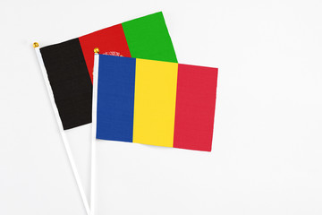 Romania and Afghanistan stick flags on white background. High quality fabric, miniature national flag. Peaceful global concept.White floor for copy space.