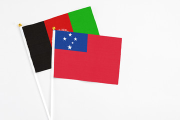 Samoa and Afghanistan stick flags on white background. High quality fabric, miniature national flag. Peaceful global concept.White floor for copy space.