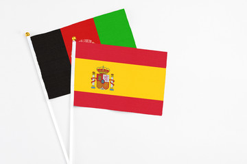 Spain and Afghanistan stick flags on white background. High quality fabric, miniature national flag. Peaceful global concept.White floor for copy space.