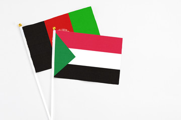 Sudan and Afghanistan stick flags on white background. High quality fabric, miniature national flag. Peaceful global concept.White floor for copy space.