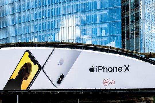 London, UK - June 22, 2018: Advertisement Billboard For IPhone X And Virgin Media On Highway Road Bridge Behind Modern Skyscraper Building