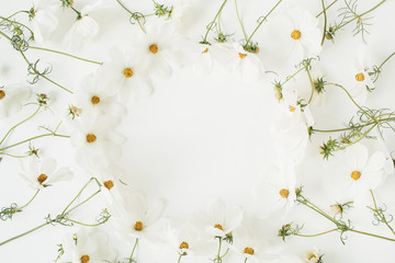 Minimal styled concept. Wreath made of white daisy chamomile flowers on white background. Creative lifestyle, summer, spring concept. Copy space, flat lay, top view.