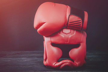 Boxing helmet and boxing gloves isolated on wooden background. Concept of sport and active leisure. Equipment for boxing, kickboxing. Playing sports, taking care of figure, fight and self-defense.