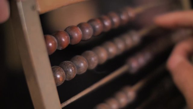 Financial concept. Close up on hand moving beads of abacus