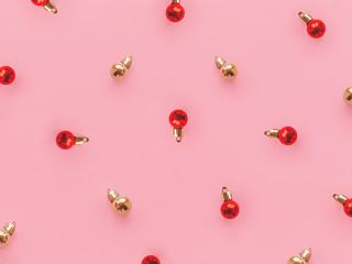 Christmas decorations Top view photo Pattern with red and gold small glass balls on a pink background