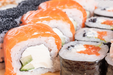 Assorted rolls and poppies. On the plank. On a red background.