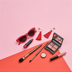 Fashion beauty coral product layout. Woman Essentials cosmetic makeup Set. Collection beauty accessories. Trendy Eye shadow, Brushes, lipstick. Coloful red art Flat lay.Creative make up artist concept