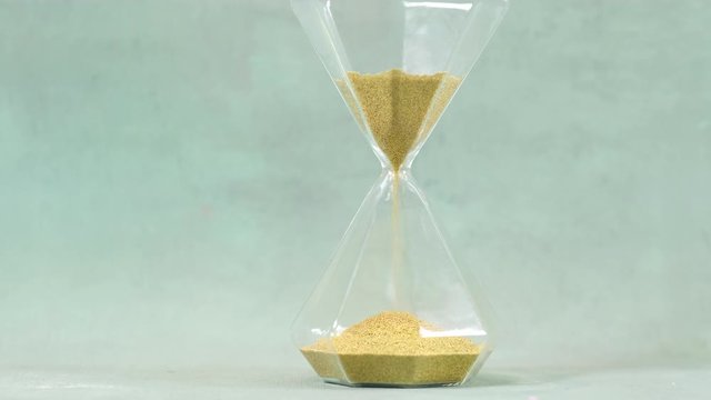 Sand flowing through an hourglass concept for time running out