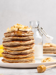 Breakfast banana pancakes stack decorated with chopped walnuts honey and banana slices