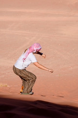 A woman riding a sandboarding