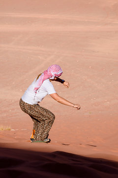 A Woman Riding A Sandboarding