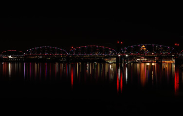 Fototapeta na wymiar Bridge at night with reflections from the city