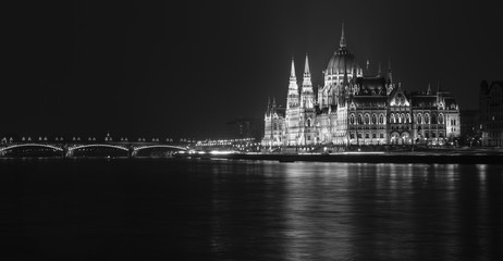 Fototapeta premium Dramatic black and white night view of the Hungarian Parliament by the river Danube