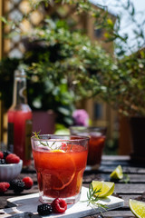 Cold refreshing lime, blackberry and raspberry lemonade with ice on wooden rustic table
