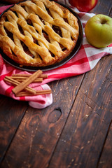 Homemade pastry apple pie with bakery products on dark wooden kitchen table