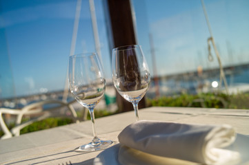 glasses of wine on a table in a restaurant with sea view