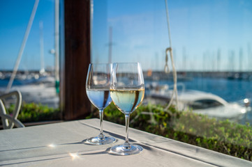 glasses of wine on a table in a restaurant with sea view