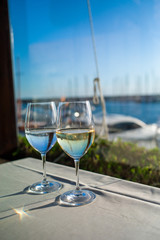 glasses of wine on a table in a restaurant with sea view