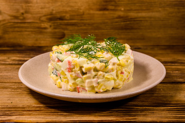 Salad with crab sticks, boiled eggs and cucumbers on a ceramic plate