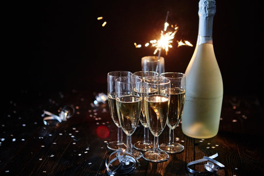 Party composition image. Glasses filled with champagne placed on black table