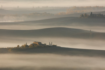 Tuscan landscape at sunrise under the fog