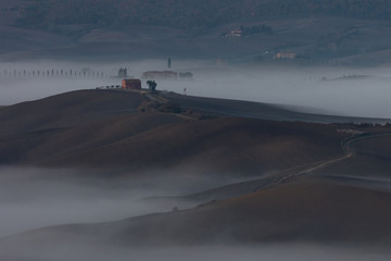 Fototapeta na wymiar Tuscan landscape at sunrise under the fog