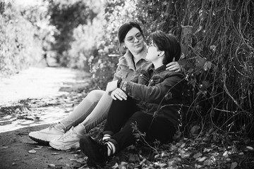 LGBT women. Young lesbian couple walking in the park together. Delicate relationship. Selective focus