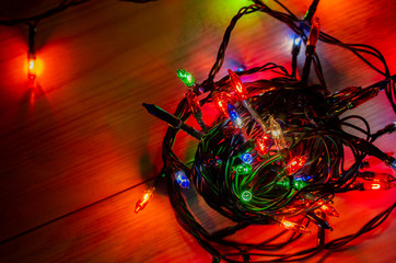 Fototapeta na wymiar lights from a Christmas garland in a dark room, burning light bulbs, winter Christmas mood