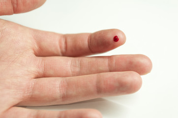 the wound on the hand on the finger close - up, cut, prick on the finger, a drop of blood on the...