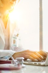 Portrait of doctor sitting at computer desk in hospital