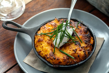 julienne in the pan on a wooden table outside at a restaurant
