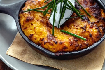 julienne in the pan on a wooden table outside at a restaurant